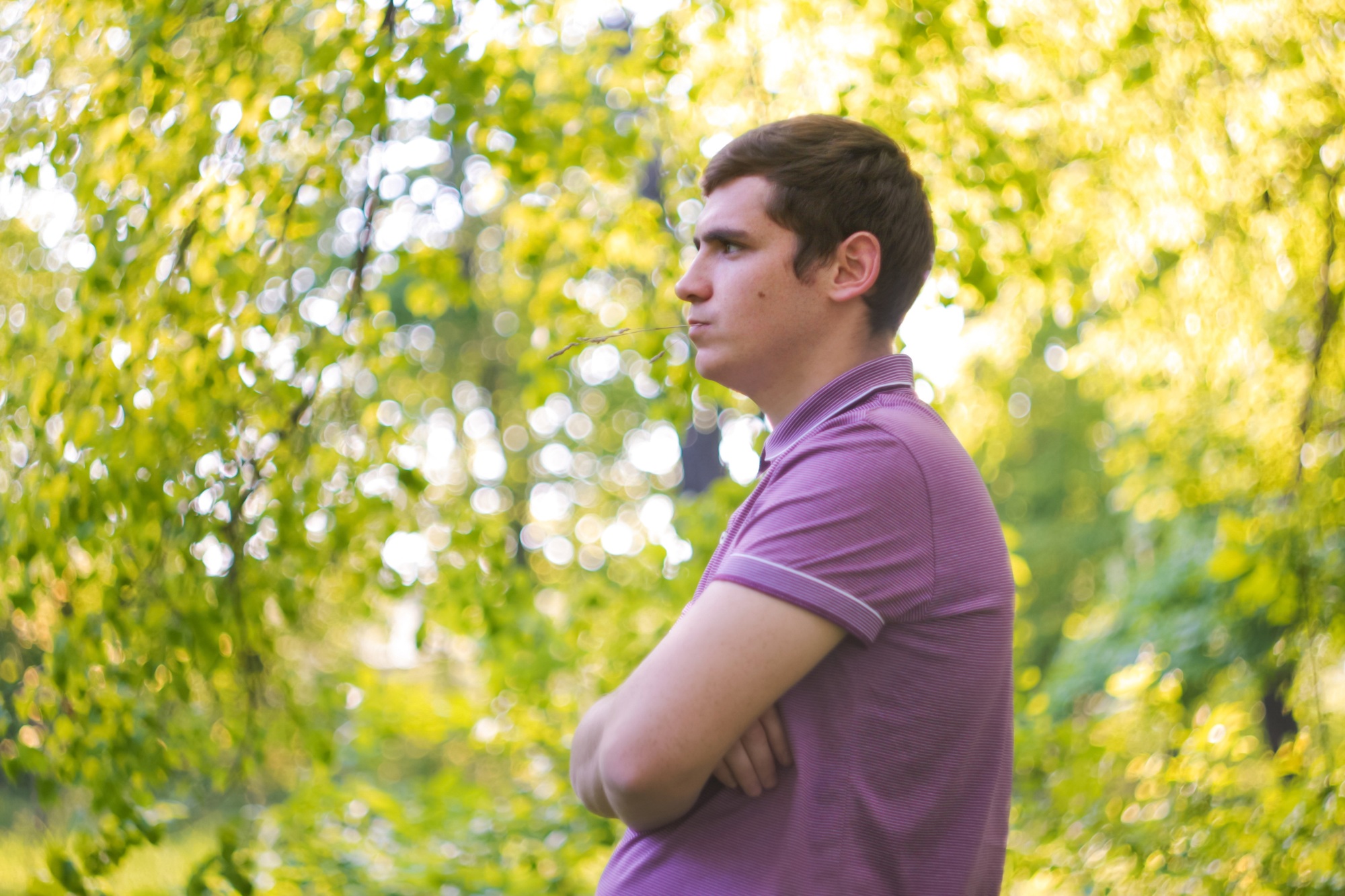 Defocus pleasant cheerful handsome young man. Profile view. Nature green garden background. Mindfuln